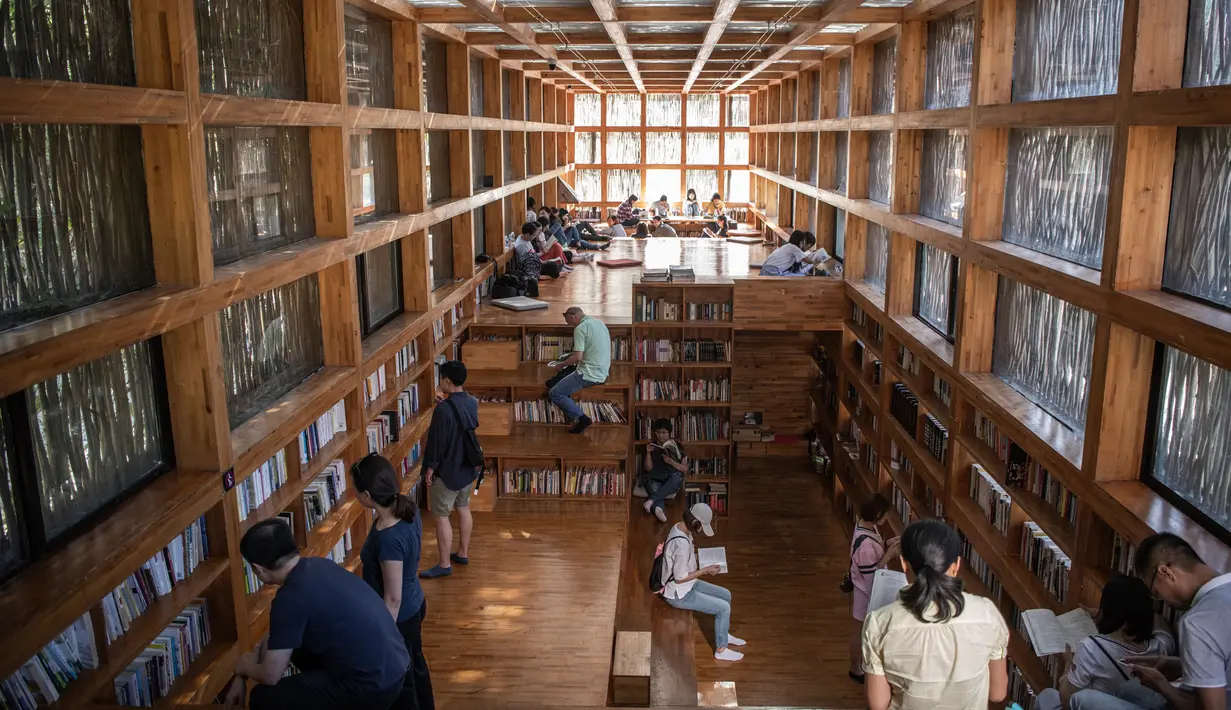Dalam gambar pada 15 September 2018, orang-orang membaca di Perpustakaan Liyuan, pinggiran kota Beijing. Untuk membaca di sini, pengunjung harus mengantre lantaran gedung itu hanya boleh dimasuki oleh 40 orang. (FRED DUFOUR/AFP)