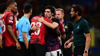 Gelandang Newcastle United, Sandro Tonali (tengah) memeluk bek AC Milan, Fikayo Tomori setelah berakhirnya laga matchday pertama Grup F Liga Champions 2023/2024 di San Siro Stadium, Milan, Rabu (20/9/2023) dini hari WIB. (AFP/Marco Bertorello)