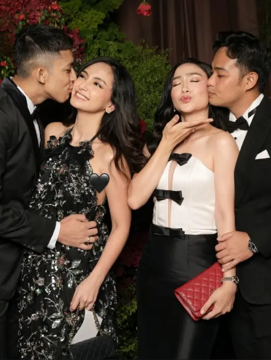 Febby Rastanty mengenakan long dress strapless dengan bagian atas putih dihiasi pita hitam serasi dengan roknya. Ia didampingi suaminya yang mengenakan setelan jas hitam. [@valtifanka]