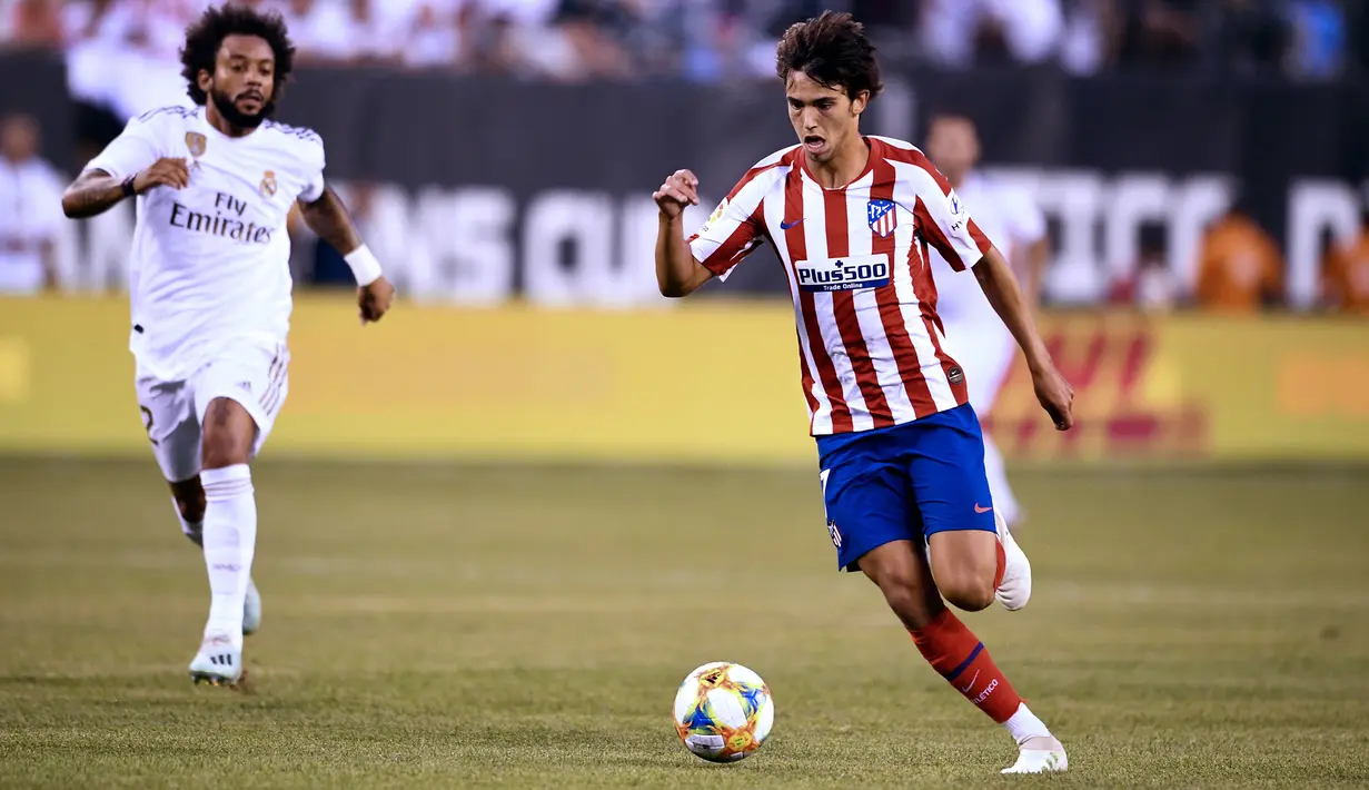Gelandang baru Atletico Madrid, Joao Felix menggiring bola dari kejaran bek Real Madrid, Marcelo selama pertandingan ICC 2019 di Metlife Stadium Arena di East Rutherford, New Jersey (26/7/2019). Joao Felix diboyong Atletico dari klub Portugal, Benfica seharga 126 juta euro. (AFP Photo/Eisele)