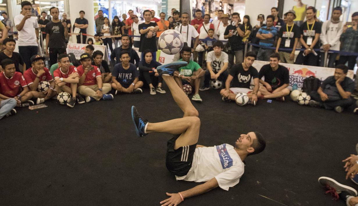 Seorang freestyler memainkan bola sambil tidur pada acara  Indonesian  Freestyle Football Championship 2015 di Mall Pluit Village, Jakarta, Sabtu (14/11/2015). (Bola.com/Vitalis Yogi Trisna)
