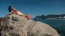 Seorang pria bernama Davi de Oliveira Moreira berjemur di Pantai Ipanema di Rio de Janeiro, Brasil, Rabu (3/5). Davi menjadi salah satu bagian dari penggila putri duyung yang sedang tumbuh di Brasil. ( AFP FOTO / YASUYOSHI CHIBA)