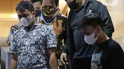 Petugas mengawal mantan Menteri Pemuda dan Olahraga Roy Suryo (kedua kiri) saat menuju rutan usai menjalani pemeriksaan di Direktorat Reskrimum Polda Metro Jaya, Jakarta, Jumat (5/8/2022). Roy Suryo ditahan sebagai tersangka kasus dugaan penistaan agama terkait unggahan meme stupa Candi Borobudur berwajah mirip Presiden Joko Widodo. (Liputan6.com/Helmi Fithriansyah)