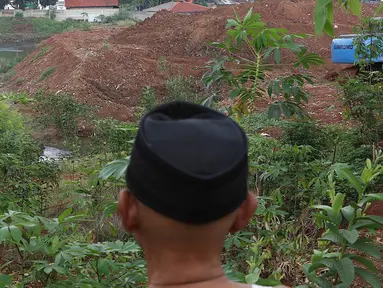 Warga melihat lokasi pembangunan Waduk Rambutan, Jakarta Timur, Rabu (24/10). Keberadaan waduk tersebut nantinya diharapkan bisa menahan luapan kali saat mendapat banjir kiriman. (Liputan6.com/Immanuel Antonius)