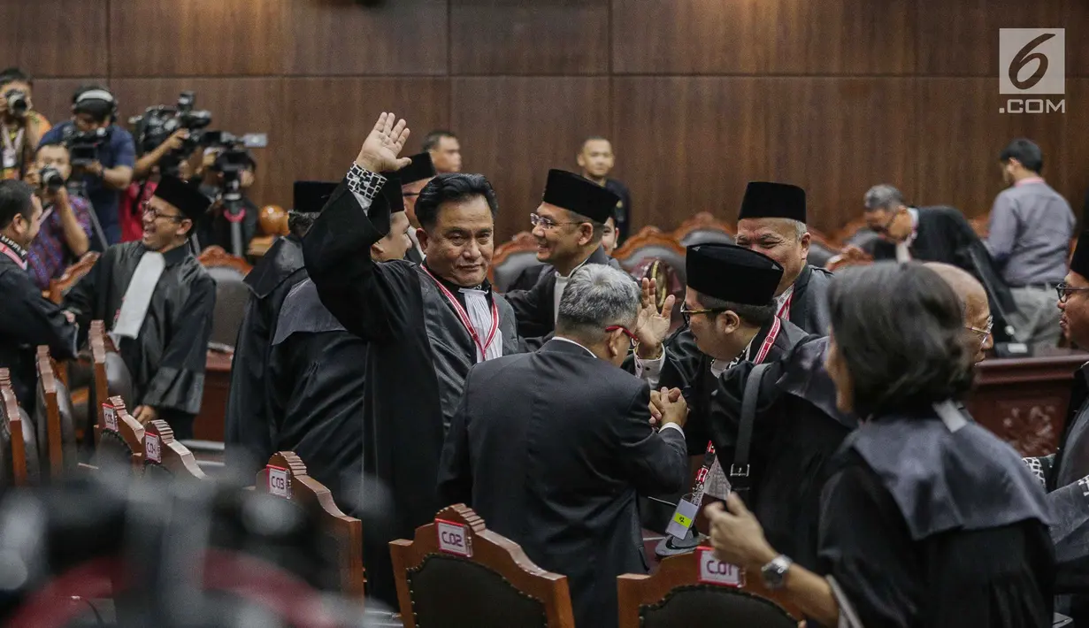 Ketua Tim Hukum Jokowi-Ma'ruf Amin, Yusril Ihza Mahendra melambaikan tangan kepada wartawan usai putusan MK di Gedung MK, Jakarta, Kamis (27/6/2019). MK menolak seluruh gugatan hasil Pilpres 2019 yang diajukan Prabowo-Sandiaga Uno yang disepakati 9 hakim konstitusi. (Liputan6.com/Faizal Fanani)