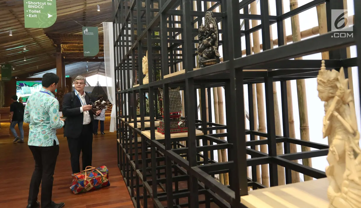Delegasi Pertemuan Tahunan IMF-Bank Dunia melihat-lihat patung saat mengunjungi pameran Indonesia Pavilion di Nusa Dua, Bali, Minggu (14/10). Lebih dari 20 ribu delegasi mengunjungi Indonesia Pavilion selama 7 hari. (Liputan6.com/Angga Yuniar)