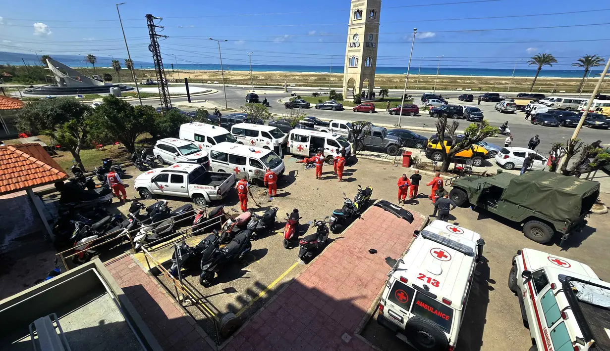 Selain menghancurkan kendaraan penyelamat, serangan udara ini memicu dampak kemanusiaan serius. Tampak dalam foto, para sukarelawan Palang Merah Lebanon memeriksa kerusakan pada kendaraan penyelamat mereka di lokasi serangan pesawat tak berawak Israel yang menargetkan markas mereka di kota Tyre, Lebanon Selatan, Senin 13 April 2026. (Kawnat HAJU/AFP)