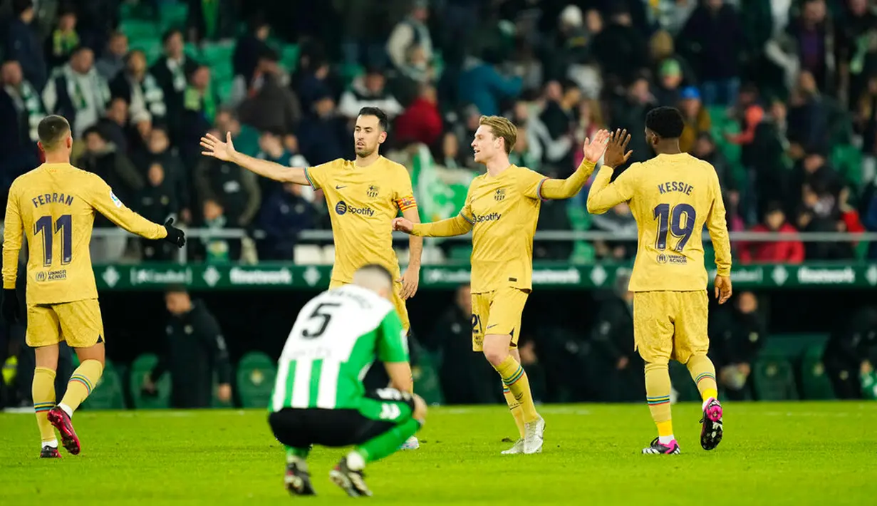 Pemain Barcelona Ferran Torres (kiri), Sergio Busquets (kedua kiri), dan Frenkie de Jong (kedua kanan), dan Franck Kessie merayakan kemenangan atas Real Betis pada akhir pertandingan sepak bola Liga Spanyol di Stadion Benito Villamarin, Seville, Spanyol, 1 Februari 2023. Barcelona genap mengoleksi 50 poin dan unggul 8 poin dari Real Madrid usai menang 2-1 atas Real Betis pada lanjutan Liga Spanyol. (AP Photo/Jose Breton)
