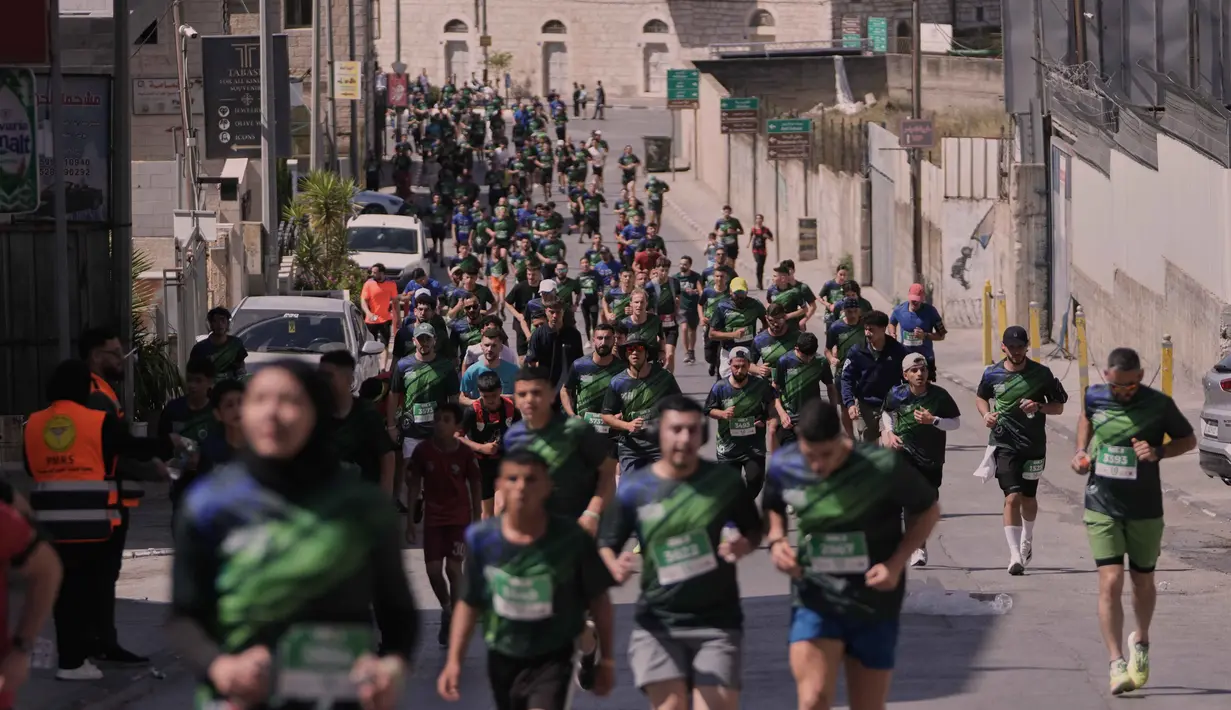 Maraton Internasional Palestina mengambil rute melintasi tembok pembatas, kamp pengungsi, dan situs-situs bersejarah di Bethlehem, Tepi Barat. Tampak dalam foto, para pelari berpartisipasi dalam Maraton Palestina di kota Betlehem, Tepi Barat, Jumat 8 Mei 2026. (AP Photo/Mahmoud Illean)