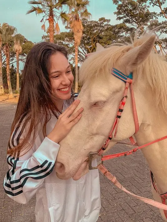 Meski tampil natural, Yasmin Napper tetap terlihat menawan saat bersama dengan kuda. Kuda dipegangnya dengan penuh perasaaan seraya tersenyum lebar. Foto ini menandakan bahwa Yasmin Napper ialah sosok pencinta binatang. (Liputan6.com/IG/@yasminnapper)