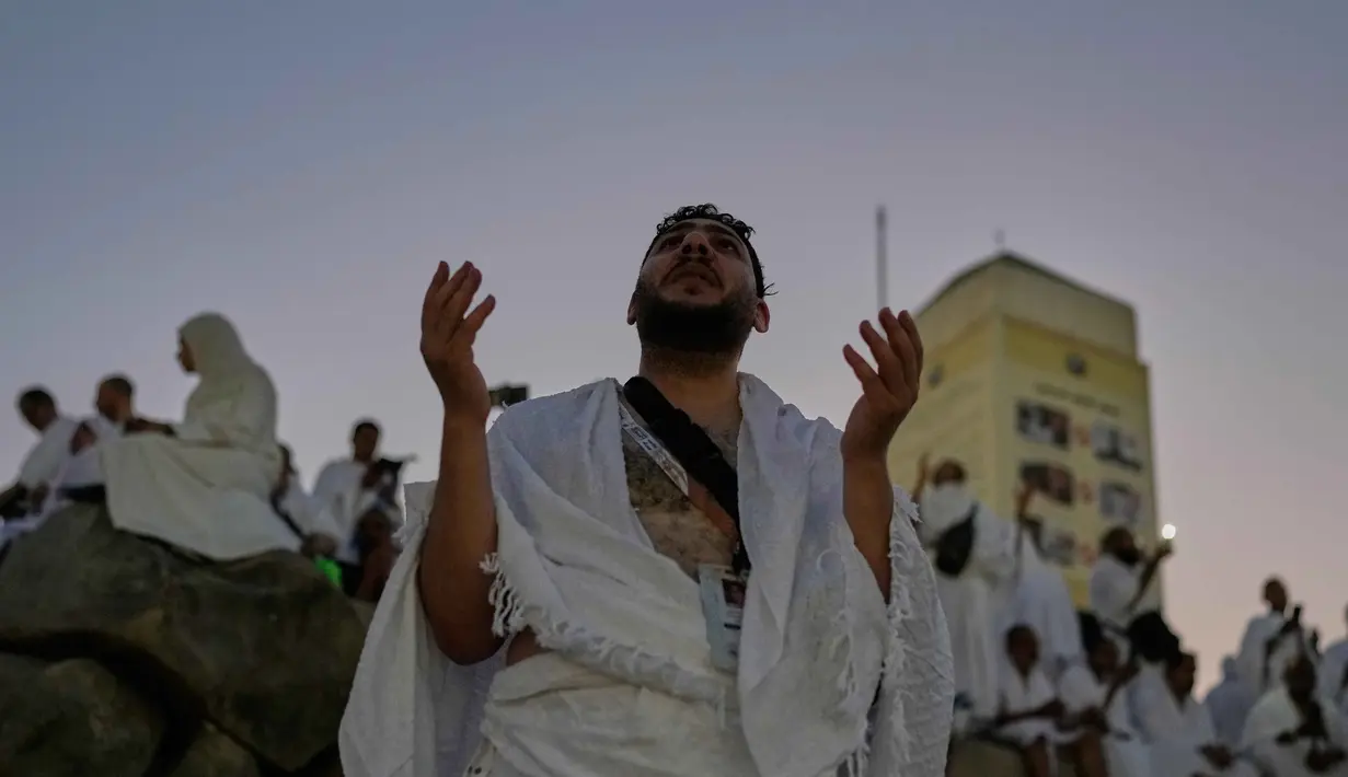 Seorang jemaah Muslim berdoa di puncak bukit berbatu yang dikenal sebagai Jabal Rahmah atau Gunung Rahmat, di Dataran Arafah, selama ibadah haji tahunan di dekat kota suci Mekah, Arab Saudi, Selasa 26 Mei 2026. (AP Photo/Altaf Qadri)