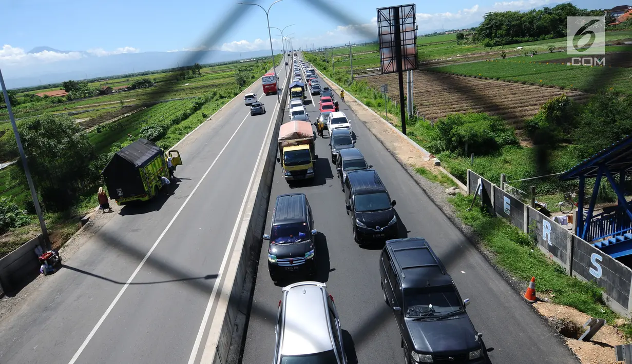 Sejumlah kendaraan antri menuju Simpang Tiga Keluar Tol Brebes, Jawa Tengah, Sabtu (23/12). Memasuki libur panjang Natal 2017, arus lalu lintas di Simpang Tiga Keluar Tol Brebes terlihat ramai lancar. (Liputan6.com/Helmi Fithriansyah)