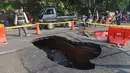 Pengendara melintas di sisi ruas jalan yang ditutup sebagian akibat amblas di Jalan Raya Lenteng Agung, Jakarta Selatan, Jumat (29/5/2026). (merdeka.com/Arie Basuki)