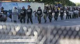 Petugas kepolisian memblokir jalan selama unjuk rasa berlangsung di Phnom Penh, Kamboja, Senin (13/7/2015). Pengunjuk rasa berpandangan aturan ini dapat memberangus pihak oposisi. (REUTERS/Samrang Pring)