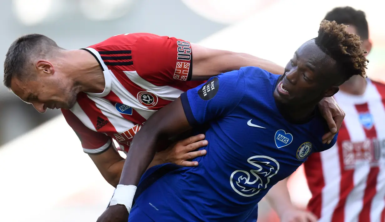 Pemain Sheffield United Oliver Norwood berebut bola dengan penyerang Chelsea, Tammy Abraham pada pekan ke-35 Liga Inggris di Bramall Lane, Minggu (12/7/2020) dini hari WIB. Chelsea dihajar 0-3 oleh Sheffield United. (Peter Powell/Pool via AP)