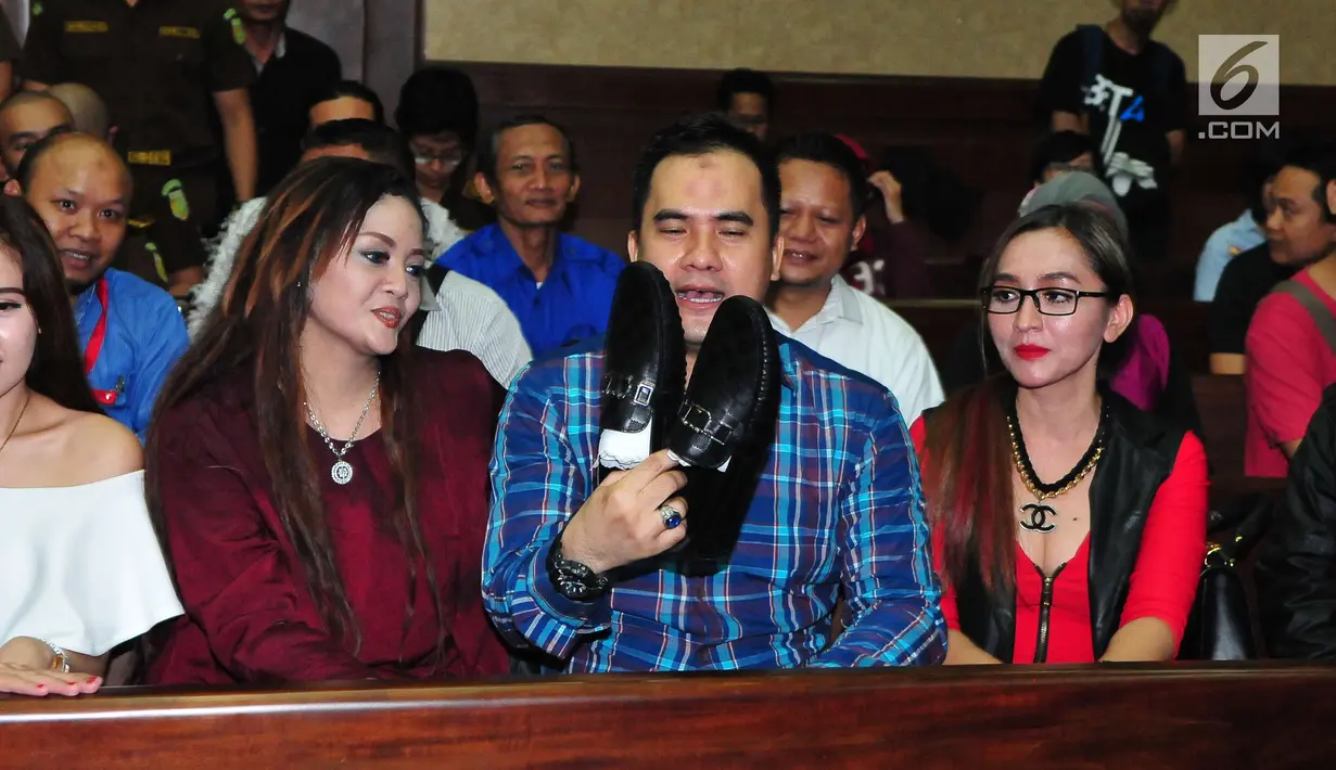 Penyanyi dangdut Saipul Jamil memperlihatkan kado ulang tahun saat menjalani sidang pembacaan putusan hakim di Pengadilan Tipikor Jakarta, Senin (31/7). (Liputan6.com/Helmi Afandi)
