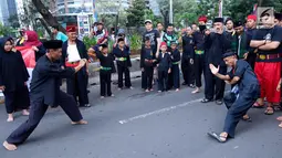 Dua pendekar saling unjuk kebolehan di hadapan warga saat Car Free Day di kawasan Senayan, Jakarta, Minggu (8/10). Aksi tersebut untuk mengkampanyekan stop informasi salah tentang susu berkadar gula tinggi. (Liputan6.com/Fery Pradolo)