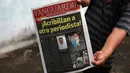 Seorang pria menunjukkan koran yang berisi berita tewasnya wartawan Leobardo Vazquez di Gutierrez Zamora, Meksiko (22/3). Vazquez adalah wartawan ketiga yang dibunuh di Meksiko tahun ini. (AP/Felix Marquez)