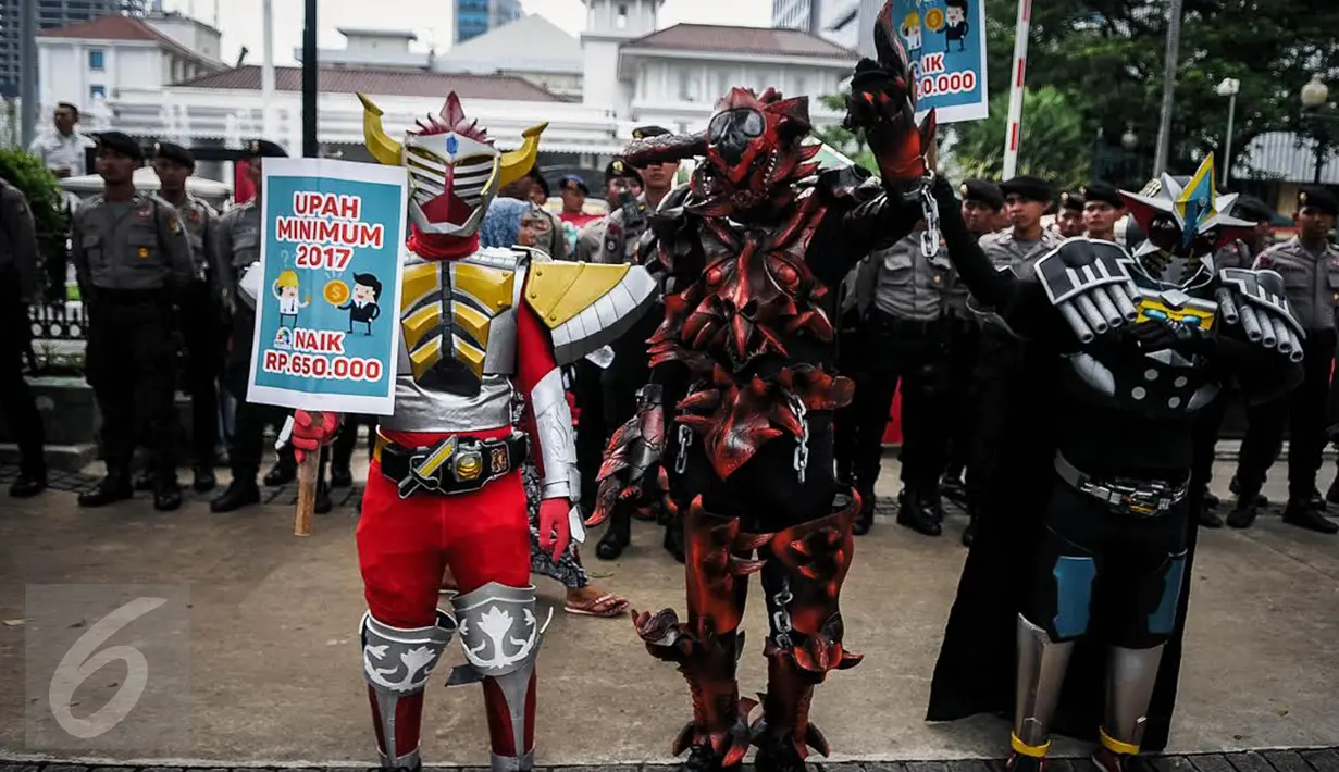 Sejumlah buruh mengenakan kostum cosplay super hero ketika berunjuk rasa di depan Balai Kota, Jakarta, Kamis (29/9). Dalam aksinya, buruh menuntut kenaikan upah mininum Rp 650ribu dan penghapusan Tax Amnesty. (Liputan6.com/Faizal Fanani)