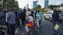 Seorang pedagang asongan menawarkan dagangannya di antara massa aksi di jalan tol dalam kota yang berada di depan Gedung DPR RI, Jakarta, Senin (30/9/2019). Adanya aksi unjuk rasa di sekitar lokasi dimanfaatkan para pedagang asongan untuk mencari rezeki. (Liputan6.com/Immanuel Antonius)