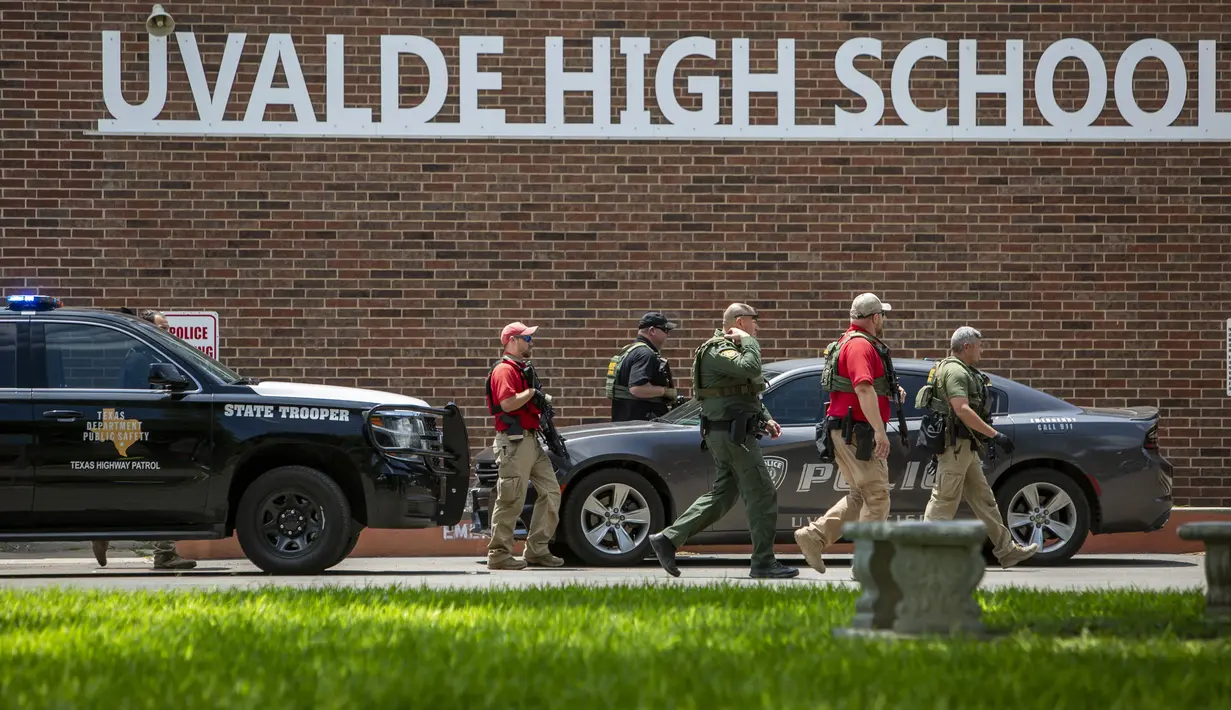 Aparat penegak hukum berjalan di luar Uvalde High School setelah penembakan dilaporkan pada hari sebelumnya di Robb Elementary School, Uvalde, Texas, Amerika Serikat, 24 Mei 2022. Gubernur Texas Gregg Abbot berkata pelaku adalah remaja berusia 18 tahun. (William Luther/The San Antonio Express-News via AP)