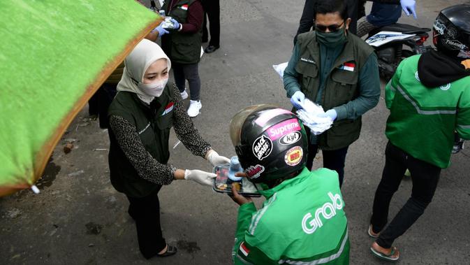 Ketua Umum Jabar Bergerak Atalia Ridwan Kamil membagikan nasi bungkus dan masker gratis saat pencanangan Garakan Nasi Bungkus di Pasar Cikutra, Kota Bandung, Selasa (14/4/2020). (Humas Jabar)