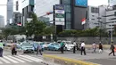 Warga menyebrang jalan Sudirman di kawasan Tosari, Jakarta, Jumat (14/12). Penggunaan pelican crossing di kawasan ini menggantikan fungsi Jembatan Penyebrangan Orang (JPO) Tosari yang akan dibongkar. (Liputan6.com/Helmi Fithriansyah)