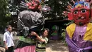 Seorang anak menggendong ondel-ondel saat bersiap untuk mengamen di kawasan Senen, Jakarta, Kamis (27/12). Hanya pengamen ondel-ondel beperalatan lengkap yang diperbolehkan. (Merdeka.com/Iqbal S. Nugroho)