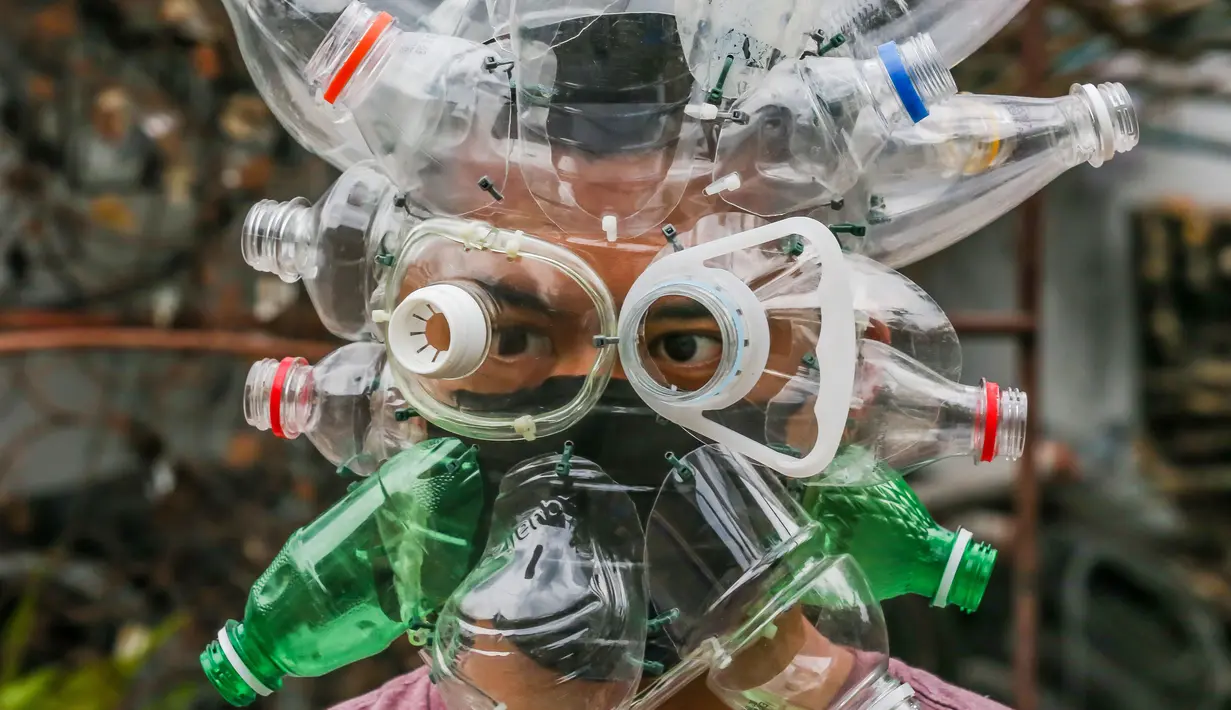 Seniman Filipina Leeroy New mengenakan masker improvisasi di studionya di Manila, 22 Mei 2020. Leeroy New menggunakan botol plastik daur ulang, gelas dan kok untuk membuat masker artistik COVID-19 yang juga akan tampilkan dalam pameran online bersama seniman visual lainnya. (Xinhua/Rouelle Umali)
