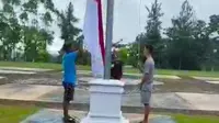 Tangkapan layar tiga remaja di Kabupaten Kuansing menurunkan bendera merah putih karena tidak petugas yang menurunkan. (Liputan6.com/M Syukur)