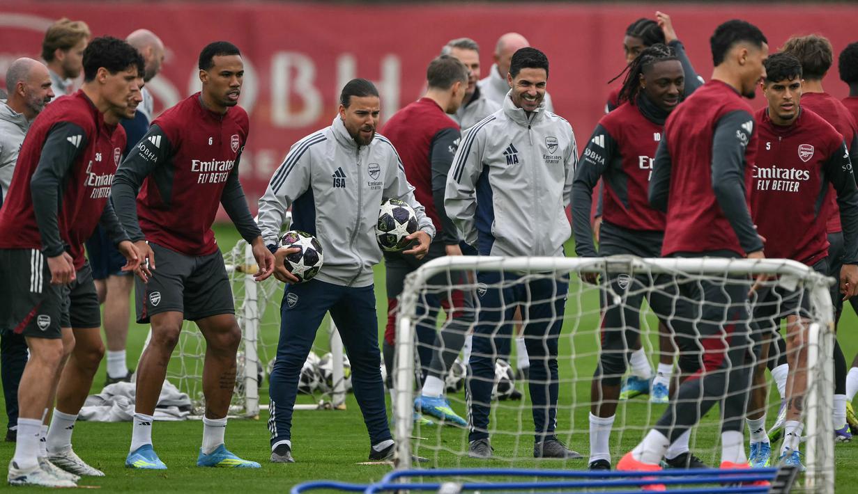 Senyum pelatih Arsenal, Mikel Arteta (tengah) pada sesi latihan jelang leg kedua semifinal Liga Champions melawan Atletico Madrid di Emirates Stadium, London, Rabu (6/5/2026) dini hari WIB. (AFP/Glyn Kirk)