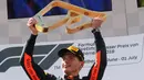 Pembalap Red Bull Max Verstappen dari Belanda mengangkat trofi di podium setelah memenangkan Grand Prix Formula Satu Austria di Red Bull Racetrack di Spielberg, Austria selatan, (1/7). Verstappen mencatatkan waktu 1:21:56,024. (AP Photo / Ronald Zak)