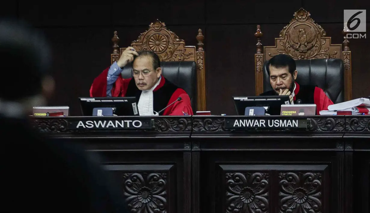 Ekspresi Ketua Majelis Hakim Mahkamah Konstitusi Anwar Usman (kanan) saat memimpin sidang sengketa Pilpres 2019 di Gedung MK, Jakarta, Selasa (18/6/2019). Sidang tersebut beragendakan mendengarkan jawaban dari termohon. (Liputan6.com/Faizal Fanani)