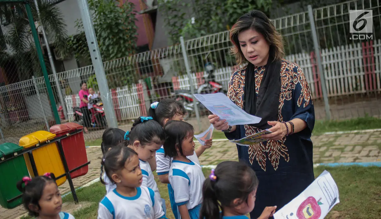 Pendiri Yayasan Pansophia Nusantara, Millie Lukito melihat gambar anak-anak Pendidikan anak usia dini (PAUD) Cahaya Permata Indonesia (CPI) di Rusunawa Marunda, Jakarta Utara, Jumat (30/11). (Liputan6.com/Faizal Fanani)
