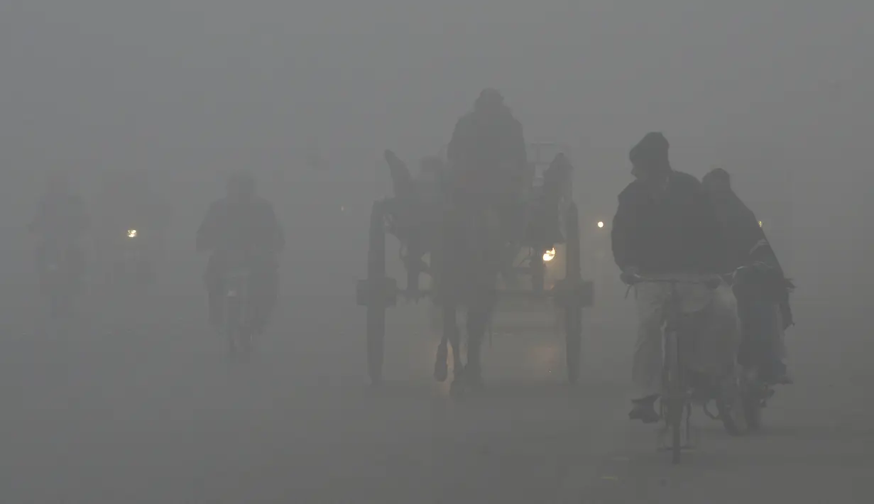 Sejumlah kendaraan melintas saat kabut asap tebal menyelimuti Lahore, Pakistan (3/1). Polusi udara telah menyebar akibat asap kendaraan, situs bangunan dan petani yang membakar tanaman di daerah di luar ibukota India. (AFP Photo/Arif Ali)