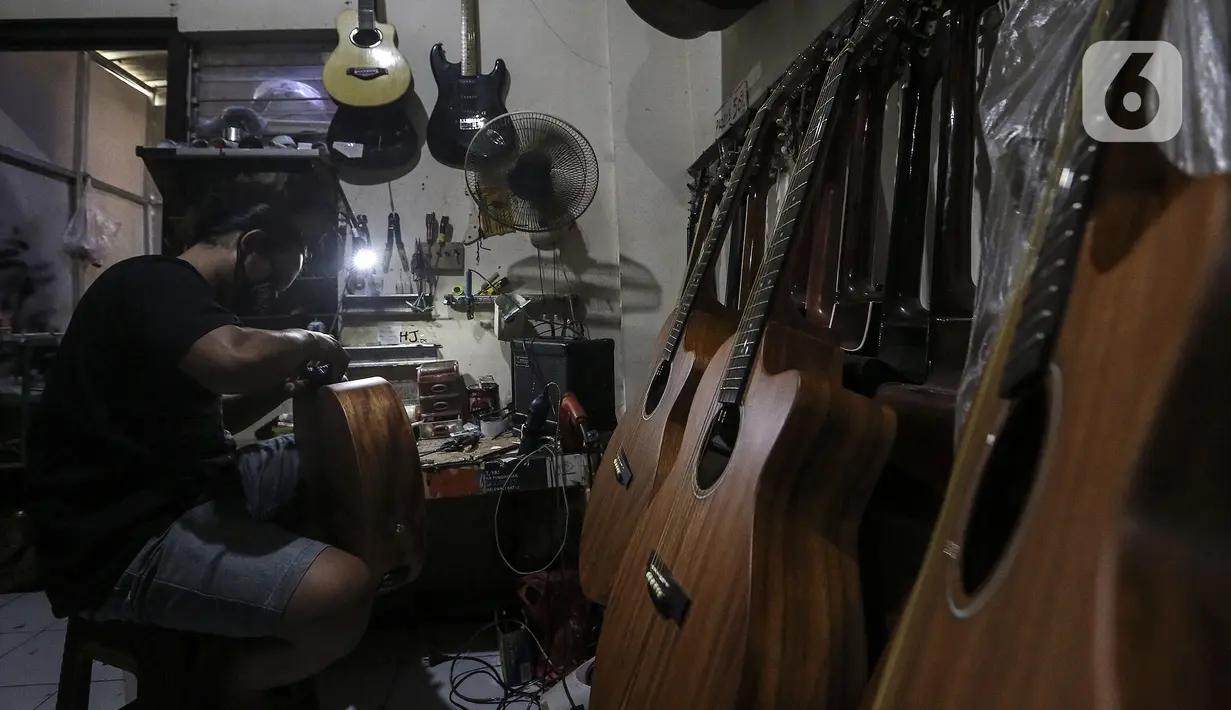 Harry saat mereparasi gitar klasik menjadi gitar listrik di toko kawasan Kedoya, Jakarta Barat, Selasa (9/2/2021). Selama pandemi COVID-19, servis gitar mengalami penurunan. (Liputan6.com/Johan Tallo)