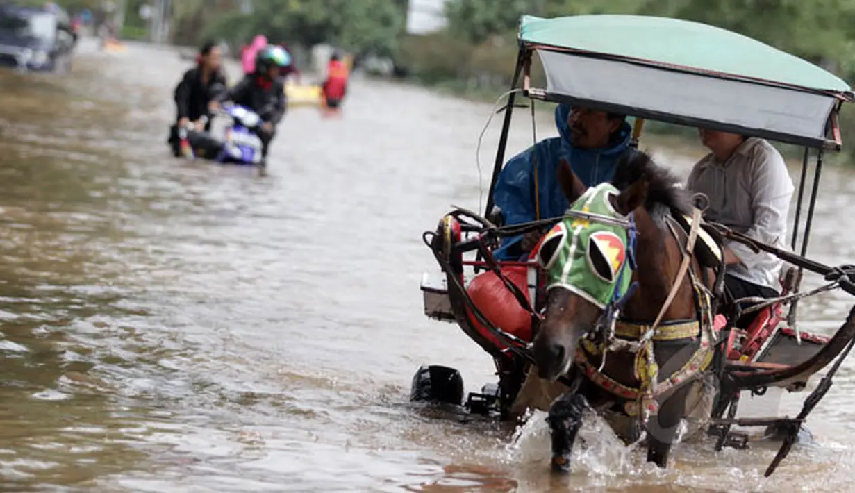 Hujan yang turun sejak Minggu (8/2) lalu, mengakibatkan kawasan Kelapa Gading, Jakarta terendam banjir. Pejalan kaki memilih naik delman untuk menembus banjir di kawasan tersebut, Selasa (10/2/2015). (Liputan6.com/Faizal Fanani)