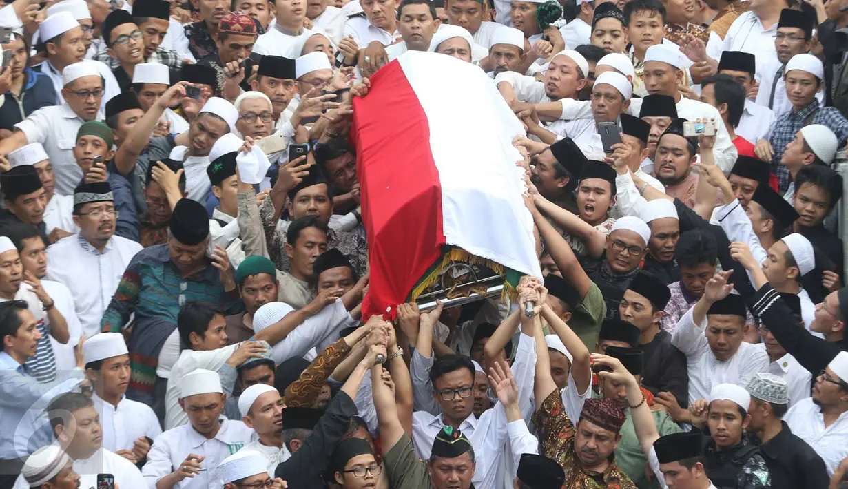 Pelayat mengantar jenazah tokoh PBNU KH Hasyim Muzadi menuju pemakaman di Ponpes Al-Hikam, Kukusan, Beji, Depok, Kamis (16/3). Hingga wafatnya KH Hasyim Muzadi masih tercatat sebagai Anggota Dewan Pertimbangan Presiden. (Liputan6.com/Immanuel Antonius)