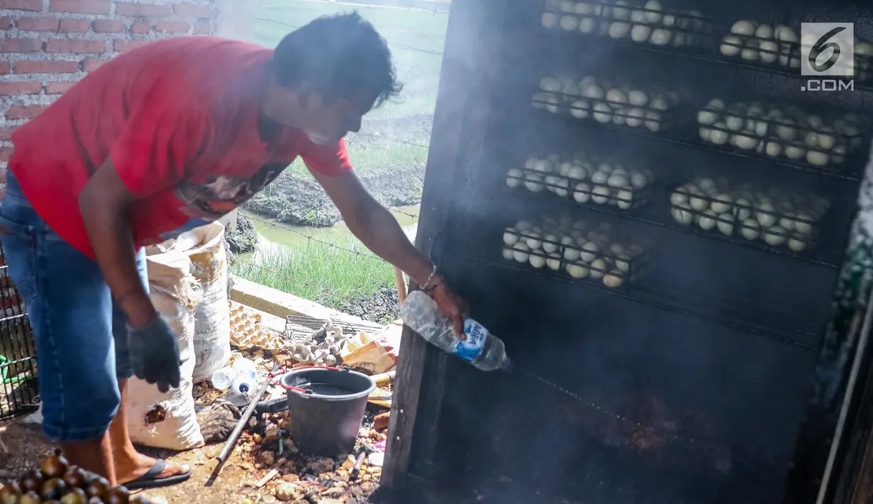 Warga mengolah telur asin dengan proses pengasapan di industri rumahan telur asin Cah Angon, Limbangan, Brebes, Jawa Tengah, Minggu (2/7). (Liputan6.com/Faizal Fanani)