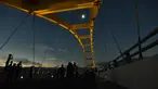 Warga menyaksikan fase puncak Gerhana Matahari Total (GMT) yang dilihat dari Jembatan Teluk Palu, Sulawesi Tengah, Rabu (9/3/2015). (Nanang/AFP)
