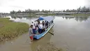 Anak-anak menggunakan perahu menuju sekolahnya dekat garis start Tour de Singkarak 2016 di Pariaman, Sumatera Barat, (10/8/2016). (Bola.com/Nicklas Hanoatubun)