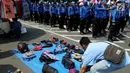 Pedagang kaki lima menjajakan barang dagangan saat Demo Hari Buruh di Jakarta, Selasa (1/5). Pedagang kaki lima ini memanfaatkan Hari Buruh untuk mengais rejeki dengan berjualan saat demontrasi berlangsung. (Liputan6.com/Johan Tallo)