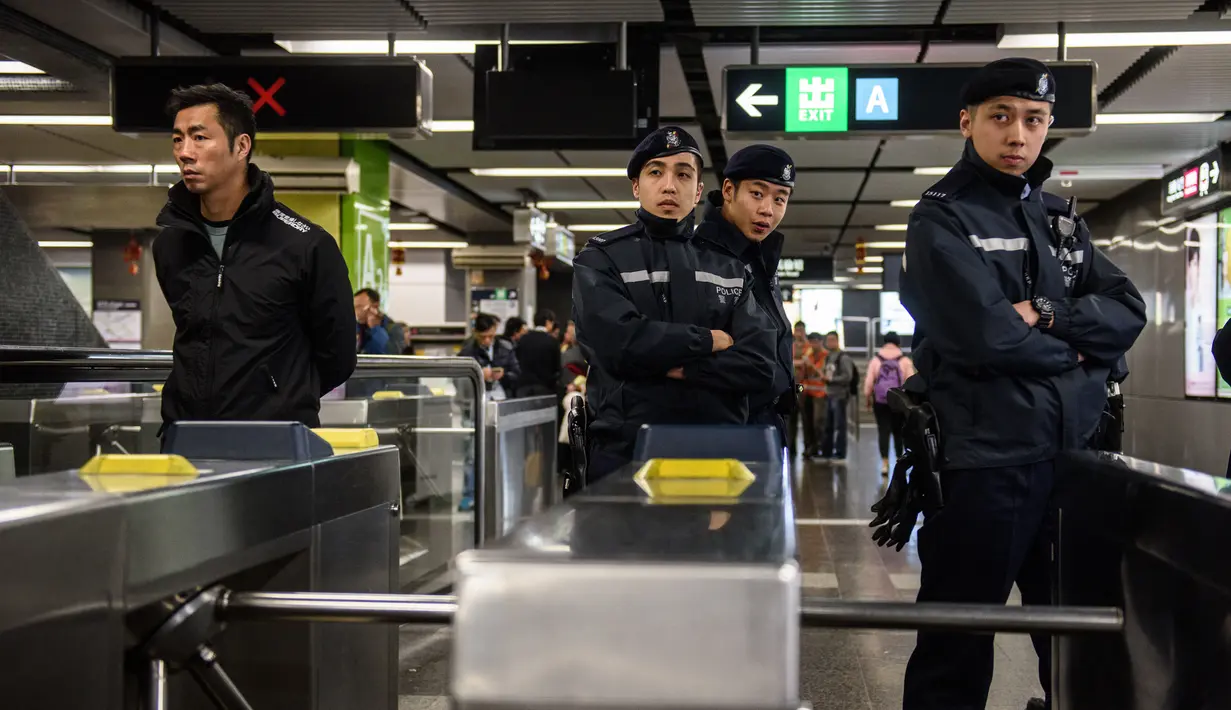 Petugas keamanan setempat menjaga lokasi terjadinya kebakaran di Stasiun Tsim Sha Tsui, Hong Kong (10/2). Akibat insiden ini, Stasiun Tsim Sha Tsui ditutup untuk sementara dan terdapat gangguan layanan di Jalur Tsuen Wan. (Handout / Apple Daily / AFP)
