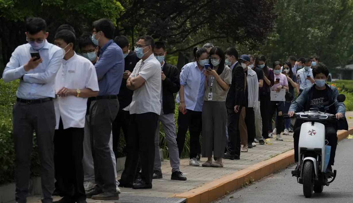 <p>Pekerja kantor dan penduduk berbaris di sepanjang jalan untuk swab tenggorokan mereka di fasilitas pengujian virus corona di Beijing, Senin (13/6/2022). Pejabat kesehatan kota mengatakan sejauh ini ada 166 kasus yang dikonfirmasi terkait dengan wabah yang dimulai di bar Heaven Supermarket di daerah Sanlitun pada Kamis, 9 Juni 2022. (AP Photo/Andy Wong)</p>