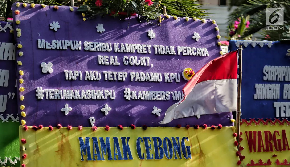 Karangan bunga kembali menghiasi depan Kantor Komisi Pemilihan Umum (KPU) Pusat dan dan ruas Jalan Imam Bonjol,  Menteng, Jakarta Pusat, Senin (6/5/2019). Puluhan karangan bunga yang berjajar rapi sebagian berasal dari seseorang yang dipenuhi kata-kata unik dan lucu. (Liputan6.com/Faizal Fanani)