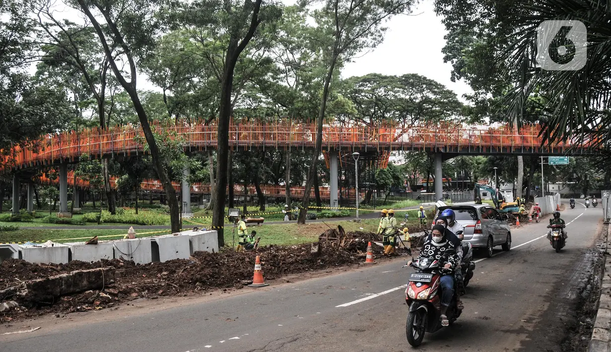 Pengendara motor melintas dekat taman Tebet Eco Garden, Jakarta Selatan, Kamis (3/3/2022). Pembangunan Tebet Eco Garden masuk proses finishing dan akan memiliki fasilitas jembatan penghubung, area bermain anak, community garden, thematic garden, dan sarana olahraga. (merdeka.com/Iqbal S. Nugroho)