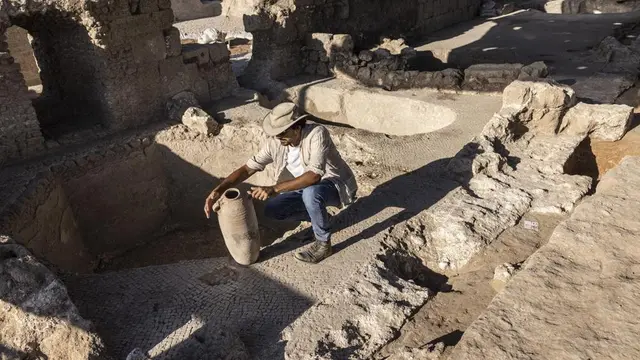 Avshalom Davidesko dari Israel's Antiquities Authority memeriksa sebuah toples di kompleks pembuatan anggur kuno yang sangat besar yang berusia sekitar 1.500 tahun di Yavne, selatan Tel Aviv, Israel, Senin, 11 Oktober 2021 (AP Photo)(
