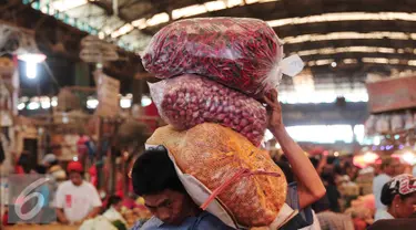 Pekerja membawa bawang merah di Pasar Kramatjati, Jakarta, Selasa (8/3). Harga bawang merah mengalami kenaikan hingga 40 persen. kenaikan harga hingga Rp 45 ribu per kg yang sebelumnya seharga Rp30 ribu per kg. (Liputan6.com/Angga Yuniar)