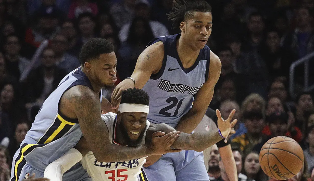 Pemain Los Angeles Clippers, Willie Reed (tengah) berusaha menjangkau bola dari adangan pemain Memphis Grizzlies pada laga NBA basketball game, di Staples Center, Los Angeles, (2/1/2018). Clippers menang 113-105. (AP/Jae C. Hong)