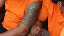 Tato tersangka kasus premanisme di Mapolres Metro Jakarta Barat, Senin (12/11). Polisi menangkap 23 pria dari dua kasus berbeda karena  tindakan perusakan, intimidasi, pengusiran, dan penguasaan lahan di Jakbar. (Liputan6.com/Immanuel Antonius)